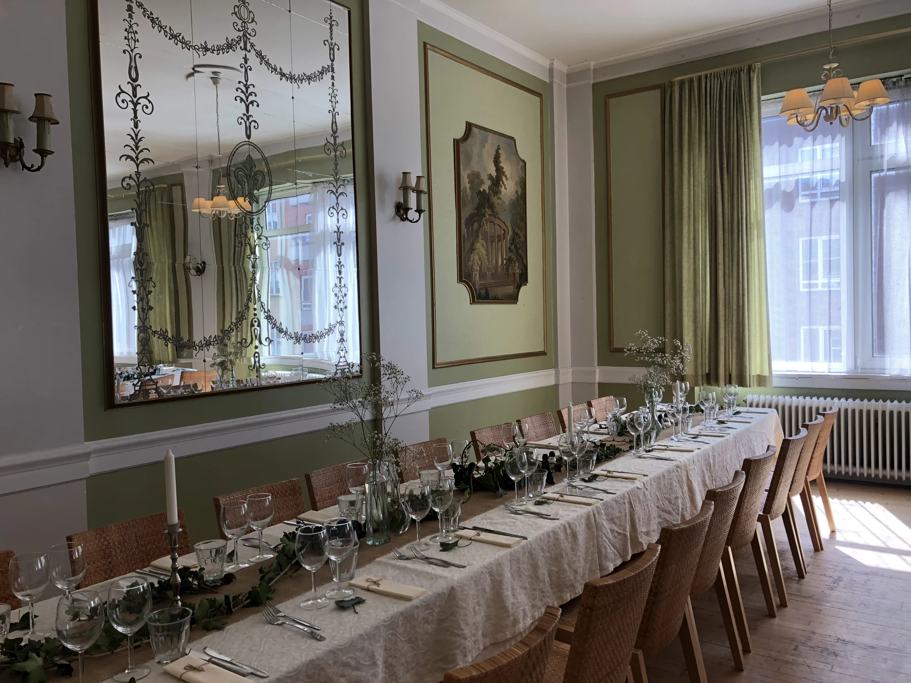 Spejlsalen med blomster, glas og dækket langbord